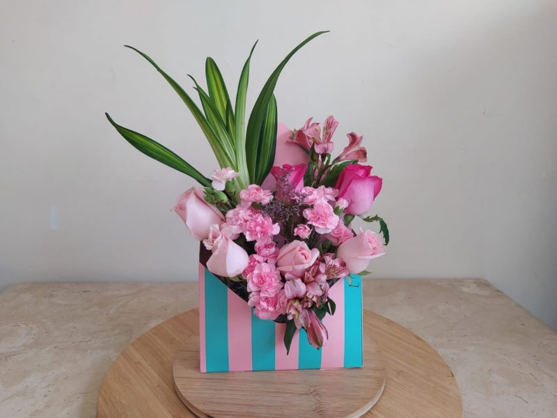 Arreglo florar sobre azul turquesa con rosa